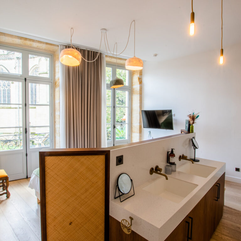 Salle de bain moderne avec douche et peignoirs suspendus dans la chambre duplex balcon - Vue Basilique du LOLA Boutique Hôtel.