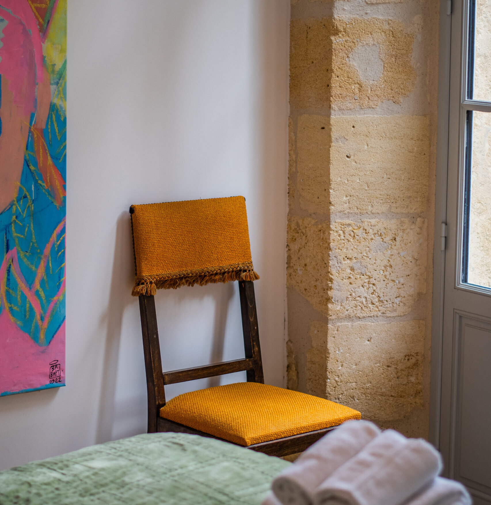 Coin détente avec chaise et décoration minimaliste dans la chambre duplex balcon du LOLA Boutique Hôtel.