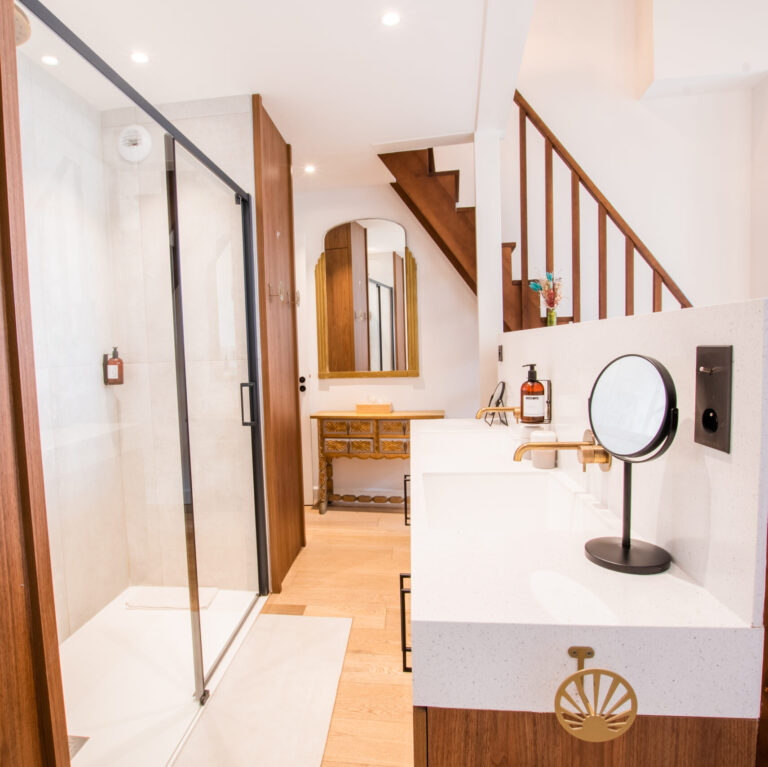 Salle de bain moderne avec douche et double vasque dans la suite Vue Basilique du LOLA Boutique Hôtel, alliant design et confort.