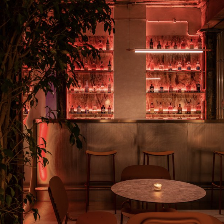 Bar élégant aux lumières tamisées, offrant une atmosphère feutrée et chic au ROSA Boutique Hôtel.