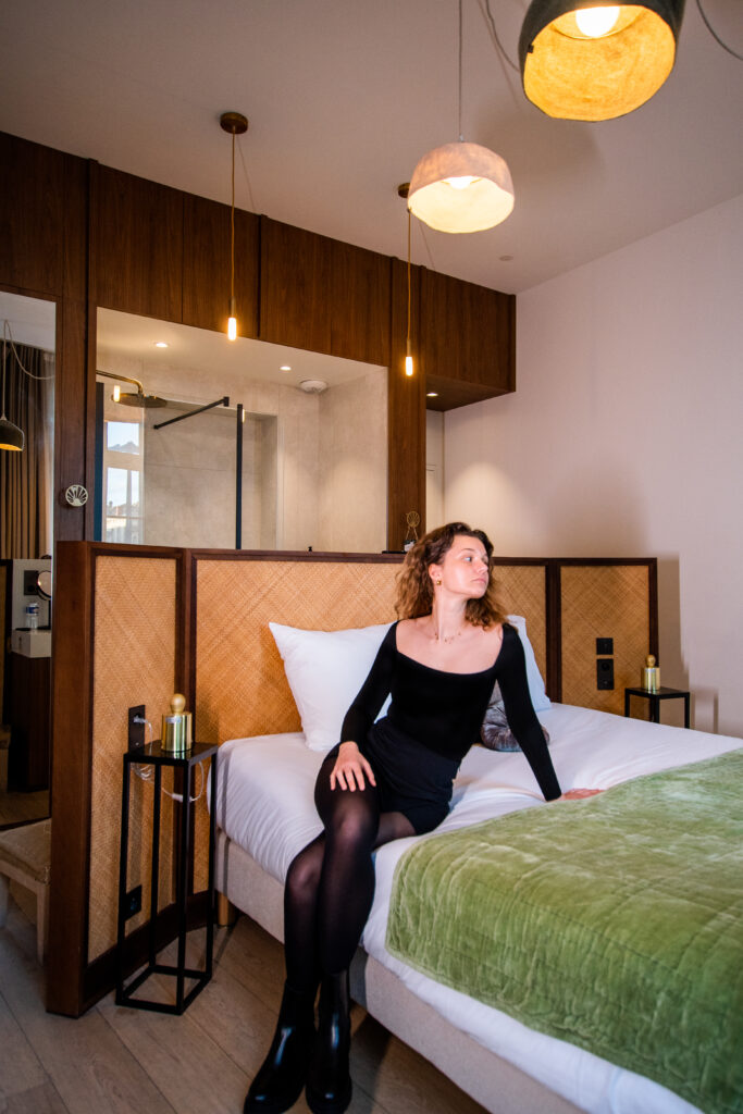 Jeune femme profitant d’un instant de relaxation dans une chambre deluxe élégante du LOLA Boutique Hôtel à Bordeaux.