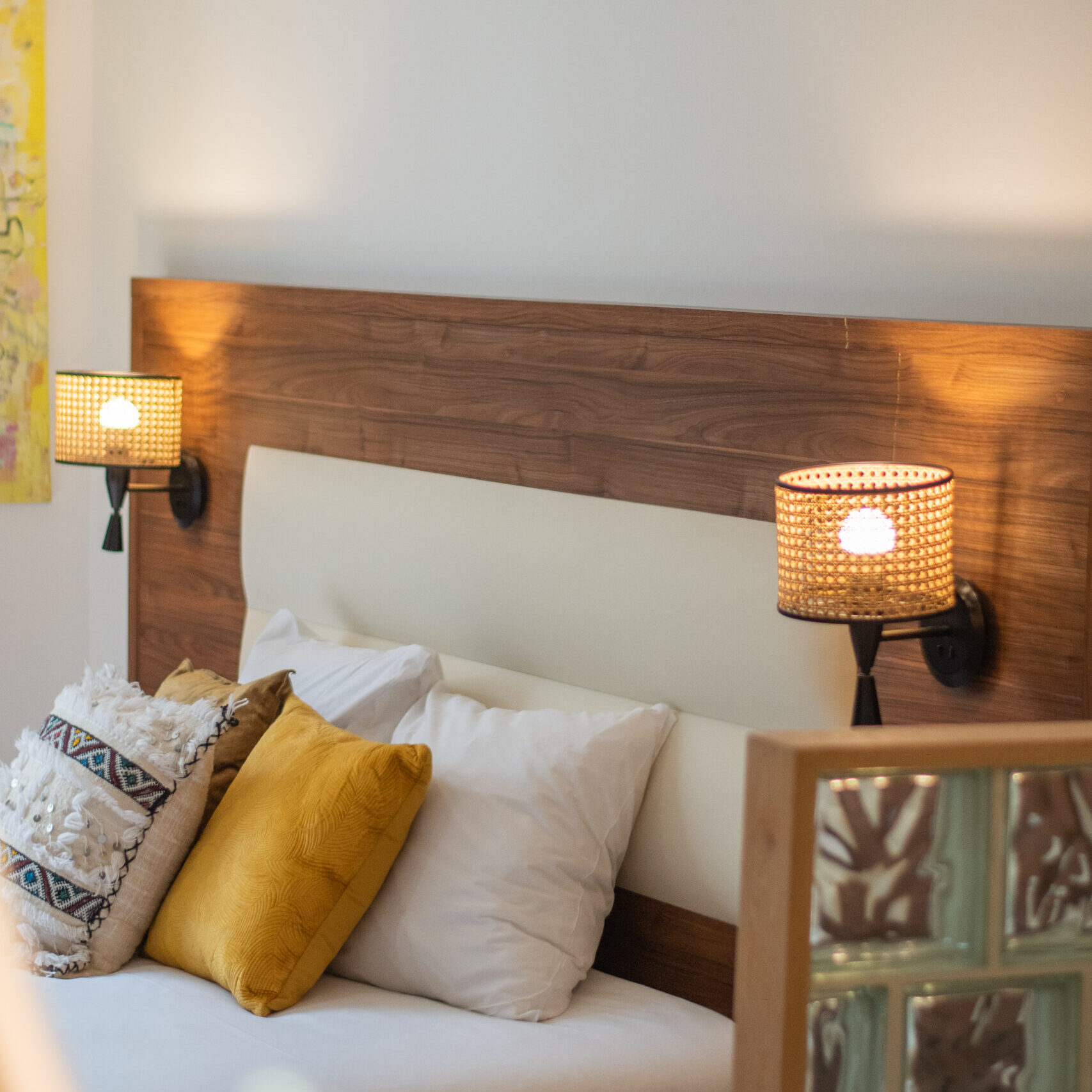 Lit confortable dans une chambre élégante de l’hôtel LOLA - O-Collection Bordeaux, avec coussins décoratifs et éclairage tamisé pour une ambiance chaleureuse.