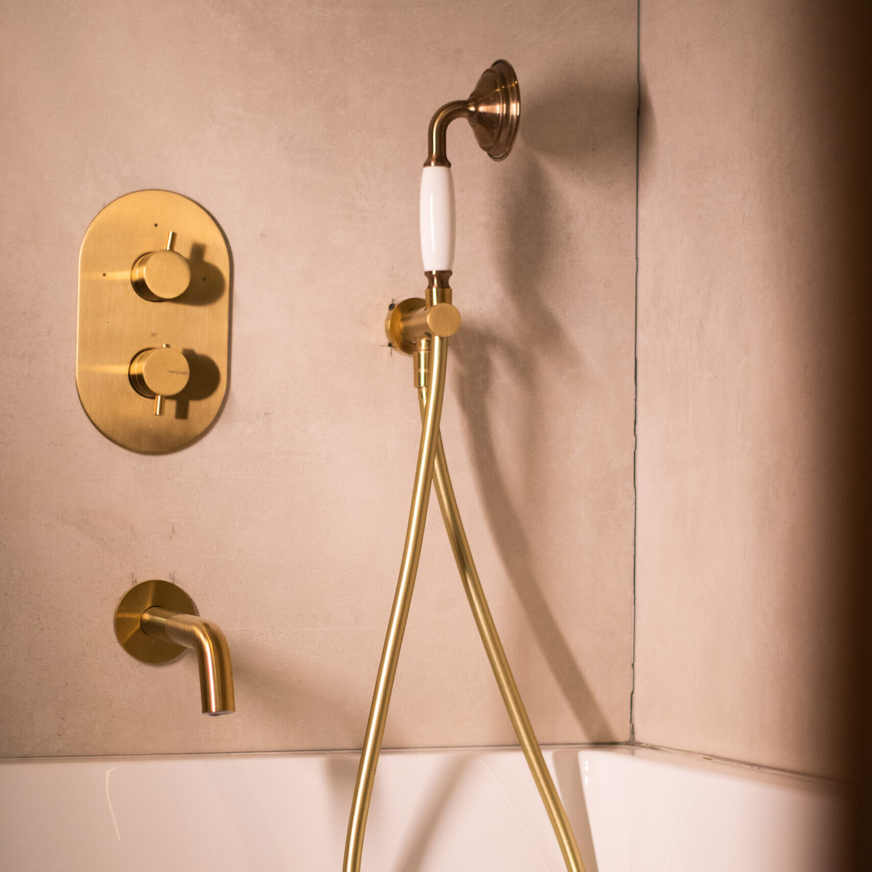 Douche moderne avec robinetterie dorée et ambiance lumineuse dans une salle de bain de l’hôtel LOLA O-Collection Bordeaux.