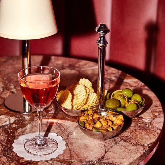 Table élégamment dressée avec des cocktails et des mets raffinés, illustrant l’atmosphère sophistiquée du ROSA Boutique Hôtel.